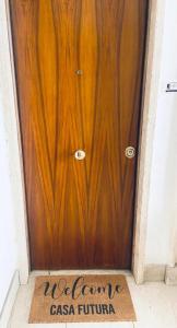 a wooden door with a welcome mat in front of it at Casa Futura in Rome