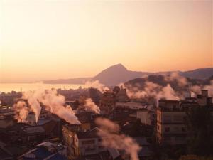 una vista de una ciudad con humo saliendo de los edificios en 〜Ｇｒａｎｄｐｉａ Ｒｅｓｏｒｔ ＯＵＧＩＹＡＭＡ〜 - Vacation STAY 50995v en Beppu