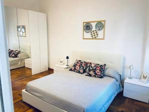 a white bedroom with a bed and a mirror at Casa Futura in Rome