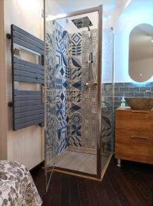um chuveiro com uma porta de vidro num quarto em le Travertin em Avignon