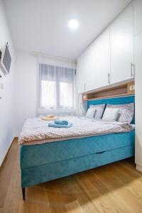 1 dormitorio con 1 cama azul grande en una habitación en Apartman Lala Zlatibor, en Zlatibor