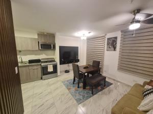 uma cozinha e sala de estar com uma mesa e um sofá em Espectacular apartamento en calle 50 na Cidade do Panamá