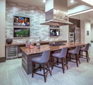 una cocina con una gran isla de cocina con sillas de bar en Woodlands Waterway Splendor, en The Woodlands