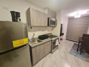 uma cozinha com um lavatório e um fogão forno superior em Espectacular apartamento en calle 50 na Cidade do Panamá