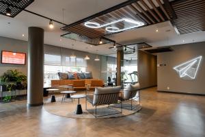 eine Lobby mit Stühlen, Tischen und einem Sofa in der Unterkunft ibis Vitoria Aeroporto in Vitória