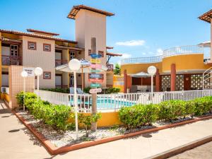 a hotel with a swimming pool in front of a building at Pousada Mares Sergipe in Estância