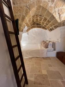 a bed in a room with a stone ceiling at La Segreta del Castello Self Check-in, private access in Gioia del Colle