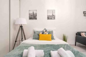 a bedroom with a bed with a yellow pillow at Zenitude Studio au coeur de Lyon in Lyon