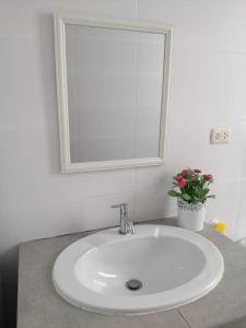 a bathroom sink with a mirror and a potted plant at Chicama D'Amore Dpto Familiar Kids & Wave on PtoMalabrigo in Puerto Chicama