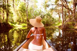 Una mujer con sombrero en una canoa en un río en The Ritz-Carlton Orlando, Grande Lakes, en Orlando