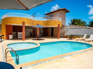 a pool at a resort with tables and chairs at Pousada Mares Sergipe in Estância