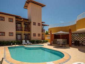 a swimming pool in front of a building with a patio at Pousada Mares Sergipe in Estância