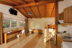 a kitchen with wooden ceilings and a living room at Agrabella Hotel in Hersonissos