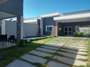 a house with a patio and a yard at VIDA NO PARAISO LAGOINHA in Lagoinha