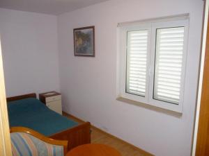 um quarto com uma janela, uma mesa e uma cadeira em Apartment Mate em Korčula