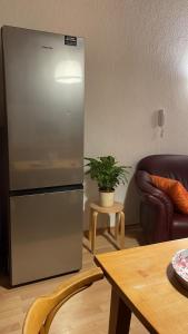 een roestvrijstalen koelkast in een woonkamer met een tafel bij 2Schlafzimmer, Wohnküche&Balkon in Oberhausen
