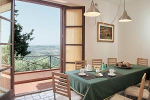 a dining room with a green table and a large window at Villa Belvedere - Località Barbiano, 3b, 50022 Greve in Chianti FI, Italy in Greve in Chianti