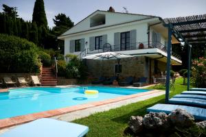 a villa with a swimming pool in front of a house at Villa Belvedere - Località Barbiano, 3b, 50022 Greve in Chianti FI, Italy in Greve in Chianti