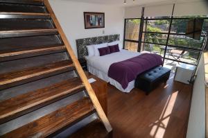 1 dormitorio con 1 cama y escalera. en Hotel Cabernet, en Valparaíso