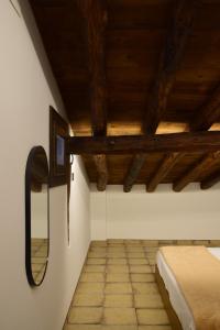 1 dormitorio con cama y espejo en la pared en La Botica, en Albarracín