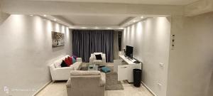 un soggiorno con mobili bianchi e lavandino di Appartement Radia a El Jadida