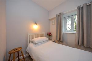 a small bedroom with a bed and a window at Gwyllt Cottages in Dwyran