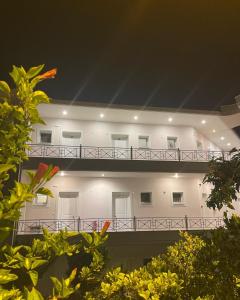 a white building with a balcony at night at Staikos in Ligia
