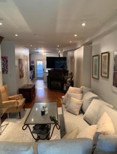 a living room with a couch and a table and a piano at Comfortable Cozy and Convenient rooms for rent in Toronto