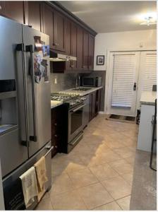 a kitchen with a stainless steel refrigerator and cabinets at Comfortable Cozy and Convenient rooms for rent in Toronto