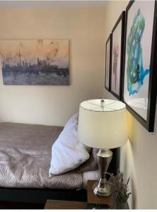 a bedroom with a bed and a lamp on a table at Comfortable Cozy and Convenient rooms for rent in Toronto