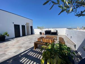 a patio with two wooden benches on top of a building at Condo in El Centro Near Malecon! in Mazatlán