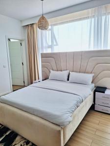 uma cama grande num quarto com uma janela grande em Avana em Nairobi