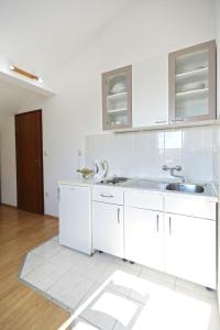 una cocina con armarios blancos y fregadero en Apartmani Katarina, en Hvar