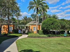 a house with palm trees and a driveway at Theme Park Gateway! in Kissimmee