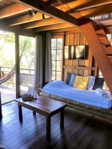 1 dormitorio con 1 cama y 1 mesa en una habitación en Pescador de Sonhos, en Praia do Rosa