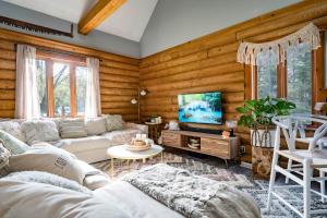 a living room with a couch and a tv at Cozy Cabin Inn in Owen Sound