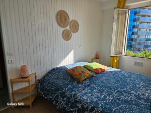 Villa Angelina في بوسولاي: غرفة نوم بسرير لحاف ازرق ونافذة