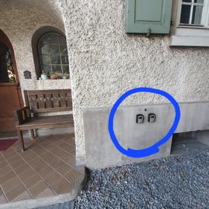 a house with a blue circle on the side of a building at New renovated flat in protected chalet in Interlaken