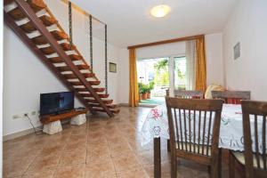 a living room with a staircase and a tv at Apartmani Katarina in Hvar