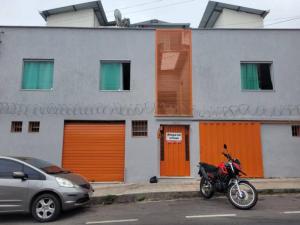 una motocicleta estacionada frente a un edificio con puertas naranjas en Kitinet Central en Belo Horizonte