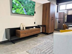 a living room with a couch and a tv on the wall at Loft hierro en excelente ubicación! in San Luis Potosí