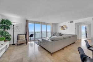 - un salon avec un grand canapé et une vue sur l'océan dans l'établissement *LUXURIOUS HIGHRISE 2BRCONDO BRICKELL- WATERVIEWS*, à Miami