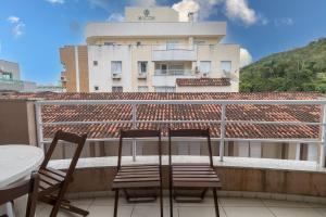 twee stoelen op een balkon met een gebouw op de achtergrond bij 449 - Lindo Apartamento de 3 dormitórios á 80m da praia de Bombas in Bombinhas