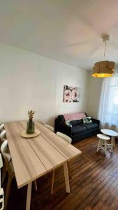 a living room with a table and a couch at Bel appartement à Villemomble in Villemomble