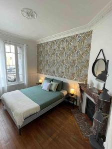 a bedroom with a bed and a fireplace and a mirror at Bel appartement à Villemomble in Villemomble