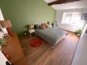 Saint-Maurice-de-RémensにあるPetite maison de villageのベッドと木の床のある寝室