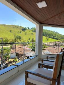a balcony with chairs and a view of a hill at Suites Silva in Capitólio