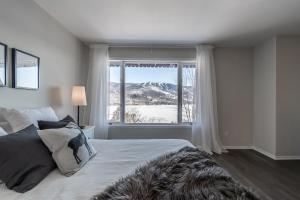 a bedroom with a bed and a large window at Hotel du lac by Rendez-Vous Mont-Tremblant in Mont-Tremblant