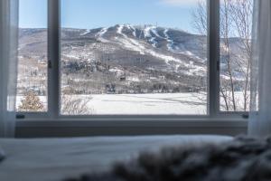 a window with a view of a snow covered mountain at Hotel du lac by Rendez-Vous Mont-Tremblant in Mont-Tremblant