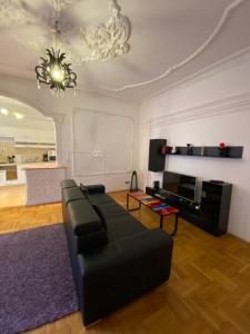 un soggiorno con divano nero e lampadario pendente di HearT of the city 2 bedroms, living rooms, bathrooms, with AC a Budapest